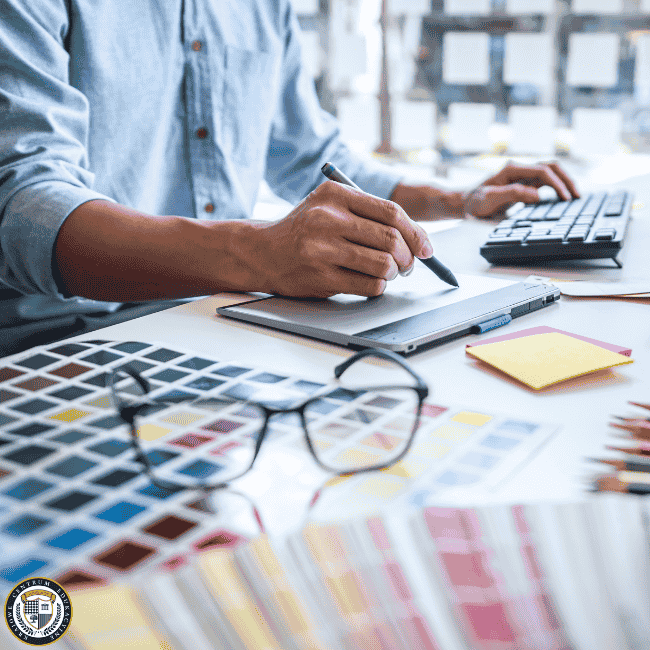 Projektant graficzny pracujący na tablecie graficznym, na biurku palety kolorów i okulary