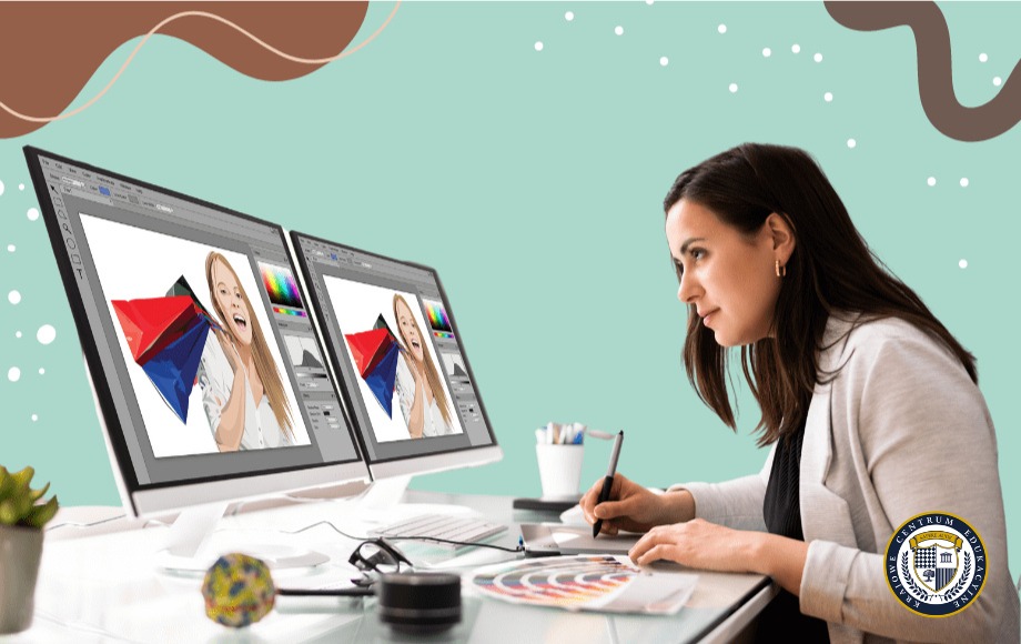 Grafik komputerowy przy pracy - kobieta w białej marynarce pracuje na dwóch monitorach z oprogramowaniem Adobe Photoshop, używając tabletu graficznego. Na biurku znajdują się również paleta kolorów, długopisy i akcesoria do projektowania graficznego. Tło w kolorze miętowej zieleni z dekoracyjnymi elementami