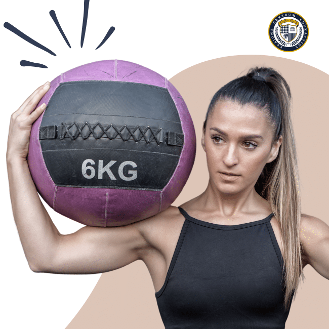 Kobieta trzymająca na ramieniu piłkę lekarską o wadze 6 kg. Temat: trening funkcjonalny