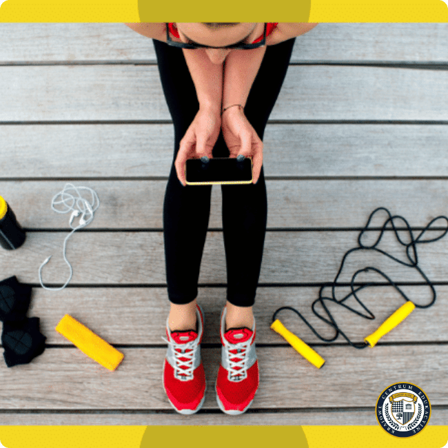 trening HIIT - kobieta w stroju sportowym sprawdzająca telefon przed treningiem