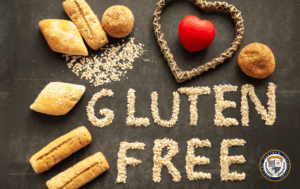 Różne bezglutenowe wypieki na ciemnym tle. Napis "GLUTEN FREE" ułożony z ziaren. Widoczne bułki, małe okrągłe wypieki oraz wiklinowe serce z czerwonym sercem w środku.