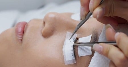 Kurs przedłużania rzęs - profesjonalistka nakłada rzęsy na modelkę