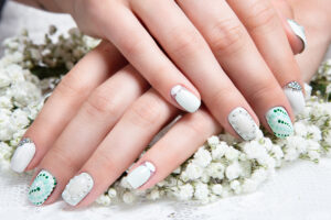 Wedding manicure for the bride in gentle tones with flowers.