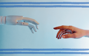 Sztuczna inteligencja - wpływ na rozwój HR. Zdjęcie przedstawia robotyczne dłoń sięgającą po ludzką dłoń.