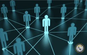 Wizualizacja skutecznego networkingu przedstawiona jako sieć połączonych niebieskich sylwetek ludzkich na ciemnym tle, gdzie jedna centralna postać jest jaśniejsza i połączona liniami z wieloma innymi, symbolizując strategiczne budowanie kontaktów biznesowych i wymianę informacji między profesjonalistami.