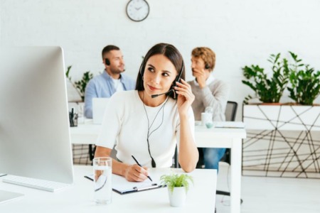 Szkolenie z telemarketingu grafika, sidebar - kobieta rozmawiająca przez słuchawkę, za nią dwie osoby rozmawiające przez słuchawki
