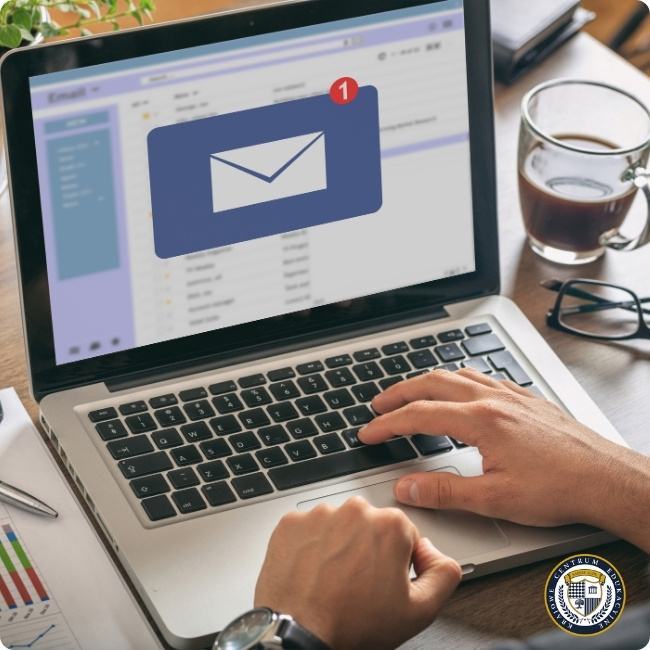 Osoba przy biurku odbiera powiadomienie o nowej wiadomości e-mail na laptopie, sugerując wykorzystanie kampanii mailingowych jako skutecznej metody „jak pozyskiwać klientów”