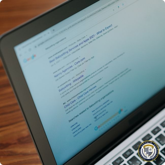 Zasady SEO: Ekran laptopa wyświetlający stronę wyników wyszukiwania Google dla zapytania związanego z usługami opieki nad dziećmi, widoczne są organiczne wyniki wyszukiwania z tytułami i meta opisami stron