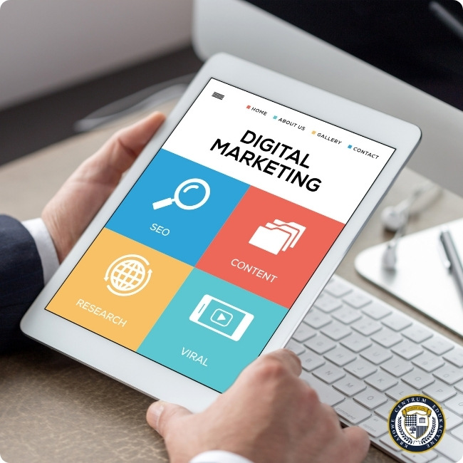 Tablet trzymany w dłoniach pokazujący stronę główną aplikacji digital marketingowej z czterema kolorowymi kafelkami: SEO (niebieski), Content (czerwony), Research (żółty) i Viral (turkusowy)