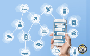 Grafika pokazująca czym jest chatbot - dłoń trzymająca smartfon z interfejsem czatu, połączony siecią z różnymi ikonami urządzeń IoT (router, antena, lodówka, pralka, aparat, osoba, kamera, telefon, pojazdy, monitor). Wizualizacja przedstawia chatbota jako centralny punkt komunikacji w inteligentnym ekosystemie urządzeń