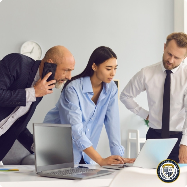 Zespół biznesowy analizujący dane przy użyciu narzędzi marketingowych na laptopie, podczas gdy starszy menedżer prowadzi rozmowę telefoniczną