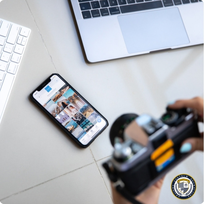 Wieloplatformowy social media marketing - smartfon z siatką zdjęć z Instagrama obok laptopa i aparatu, narzędzia współczesnego marketera