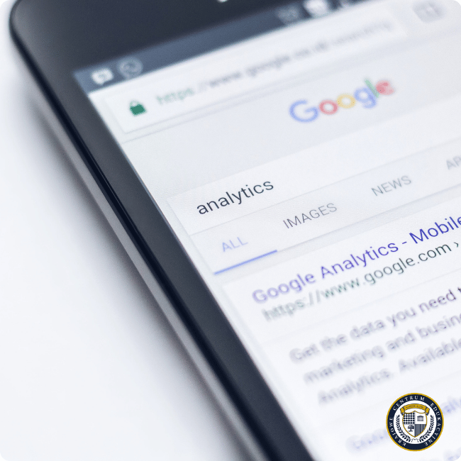 Smartfon wyświetlający wyniki wyszukiwania Google dla frazy 'analytics', istotny element w planowaniu kampanii produktowej Google Ads