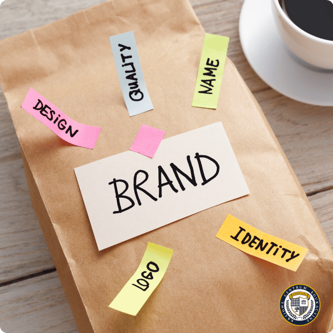Budowanie marki osobistej - papierowa torba z napisem 'BRAND' i kolorowymi karteczkami z elementami brandingu: design, quality, name, logo, identity, obok filiżanka kawy