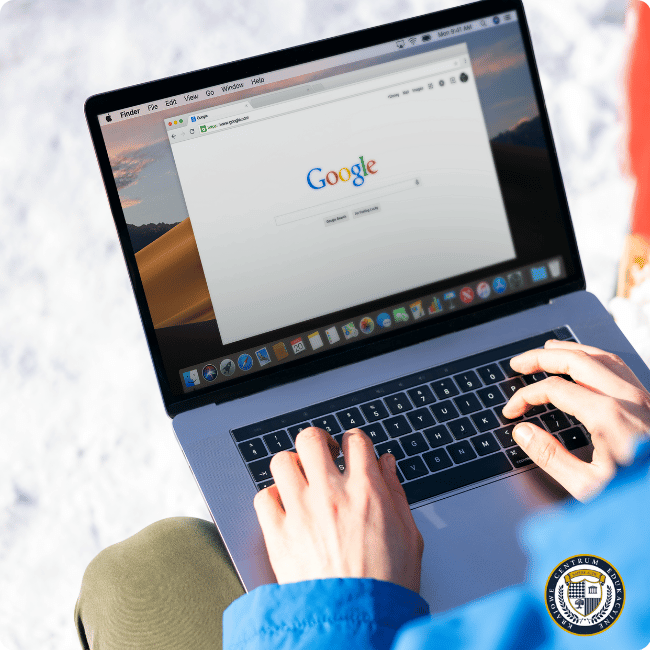 Laptop z otwartą stroną wyszukiwarki Google, na której ktoś wykonuje wyszukiwanie lokalne