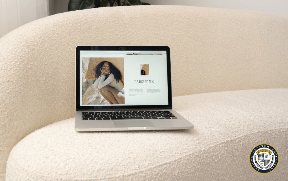 Laptop wyświetlający stronę 'About Me' z portfolio na kremowej kanapie