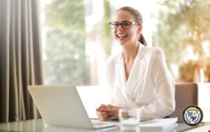 Uśmiechnięta pracownica pracująca przy laptopie