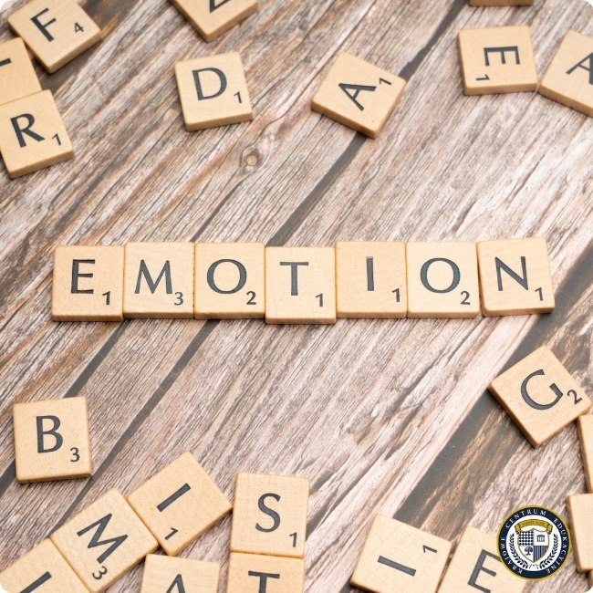 Drewniane klocki Scrabble układające słowo "EMOTION" symbolizujące znaczenie inteligencji emocjonalnej w komunikacji.
