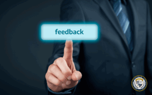 Mężczyzna w garniturze naciska świecący przycisk "feedback" - informacja zwrotna w biznesie.