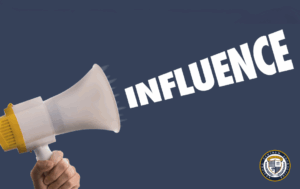 Osoba trzymająca megafon z napisem "INFLUENCE" symbolizującym wywieranie wpływu na innych