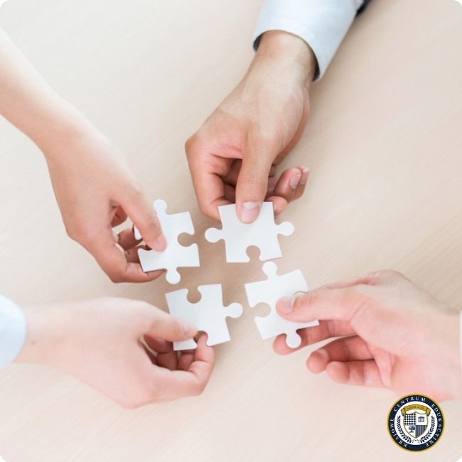 Reguła jedności w praktyce - cztery osoby łączące puzzle symbolizujące technikę wywierania wpływu przez poczucie wspólnoty