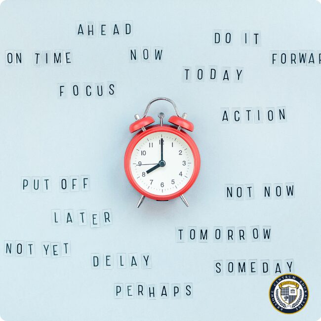 Efektywne zarządzanie czasem - czerwony budzik otoczony słowami motywacyjnymi do działania teraz