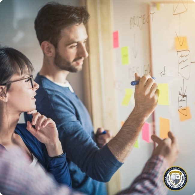 Zespół pracuje przy tablicy z kolorowymi karteczkami podczas sesji design thinking, analizując pomysły i tworząc mapę projektu