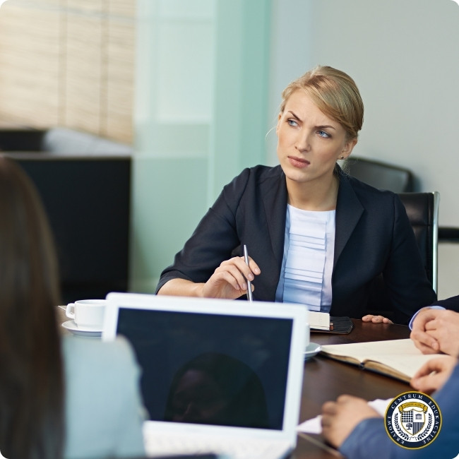 Kobieta menedżer podczas rozmowy feedbackowej w biurze - uważnie słucha z długopisem w ręku, praktykując aktywne słuchanie konstruktywnej krytyki