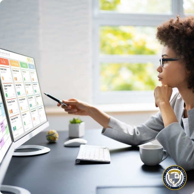 Kobieta analizująca cyfrową tablicę Kanban na monitorze, metodyki zarządzania projektami w praktyce, logo KCE
