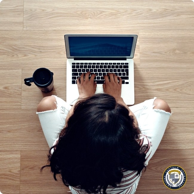 Kobieta pracująca na laptopie przy drewnianym stole z kawą - widok z góry przedstawiający kreowanie wizerunku osobistego online