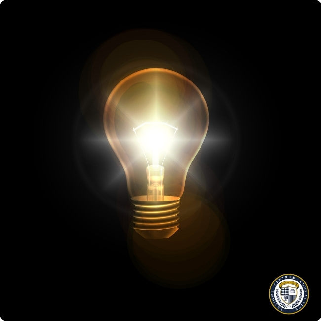 Świecąca żarówka na ciemnym tle symbolizująca innowacyjne pomysły w procesie design thinking.