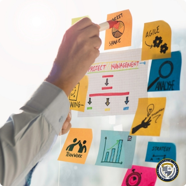 Project Manager przyklejający kolorowe karteczki na szklanej tablicy z diagramem zarządzania projektem, widoczne ikony: market share, Agile, analiza, teamwork, planning, wykresy, strategia, cele