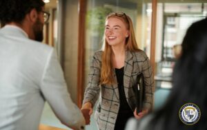 Kobieta robi dobre pierwsze wrażenie podczas spotkania biznesowego, uśmiechając się i podając rękę na powitanie