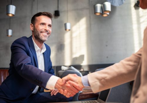 Business people shaking hands during meeting in cafe
